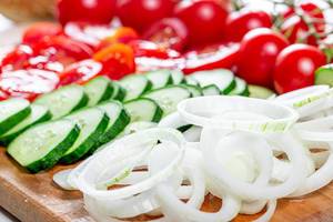 Rings of sliced onions, tomato and cucumber circles close-up