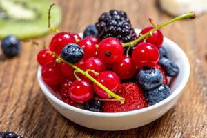 Ripe berries in a bowl on a wooden table (Flip 2019)