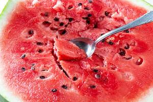 Ripe cut watermelon with seeds and spoon