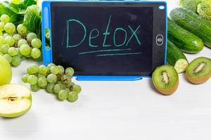 Ripe green fruits and vegetables on a white background with the inscription "detox"