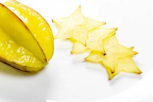 Ripe star fruit with slices on white background - carambola