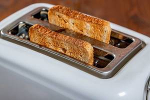 Roasted bread popping up from toaster machine