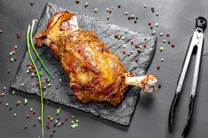 Roasted leg of young lamb with spices on black background (Flip 2019)
