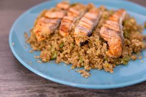 Roasted salmon strips on couscous, served on blue plate
