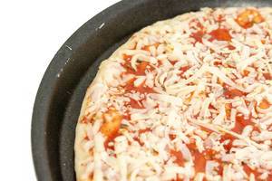 Rohe Margheritapizza auf einem runden Backblech in der Nahaufnahme