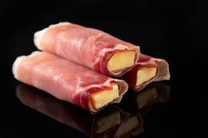 Rolled Pork Ham with yellow Cheddar cheese above black background (Flip 2019)