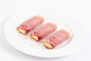 Rolled Pork Ham with yellow Cheddar cheese on the plate