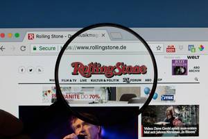 Rolling Stone Logo am PC-Monitor, durch eine Lupe fotografiert