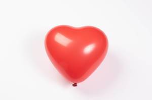 Roter Luftballon in Herzform isoliert vor weißem Hintergrund