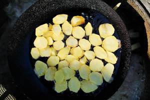 Round fried potatoes in cooking pan