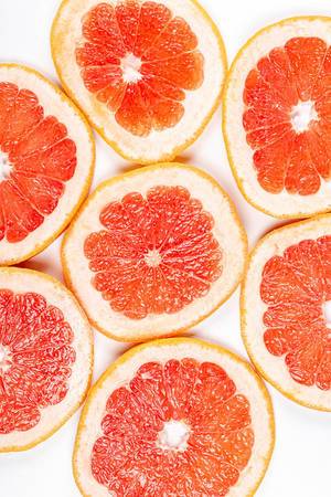 Round pieces of fresh grapefruit on a white background, top view (Flip 2020)