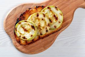 Round slices of grilled zucchini on toasted bread