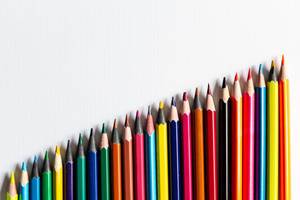 row of colored pencils on a white background