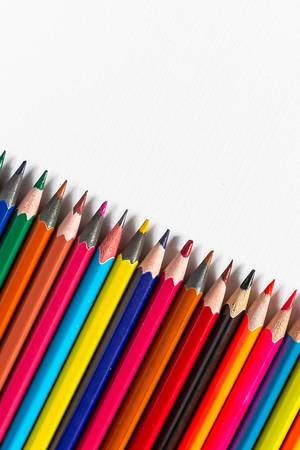 Row of colored pencils on white background
