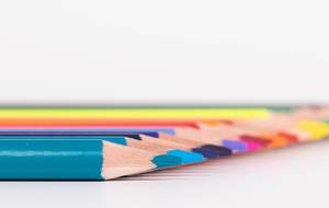 Row of colorful wooden pencils isolated on white background