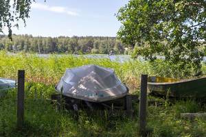 Rowing boat upside down is stored on a meadow at lake Päijänne in Finland