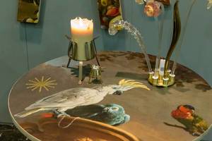 Runder Tisch kunstvoll bemalt mit Papageien und Kakadus, dekoriert mit Kerzen und Glasblumen