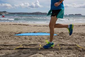 Runner  beim Training in bunten ASICS Laufschuhen, Meer im Hintergrund