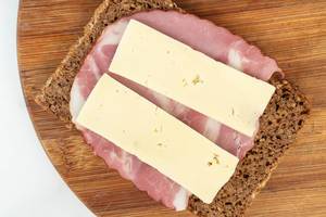 Rye Bread slice with Smoked Pork Neck on the wooden board and cheese