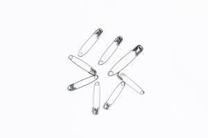 Safety pins isolated on white background Top View