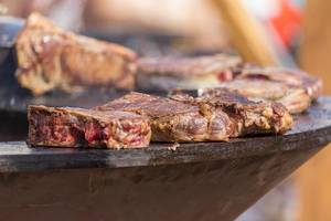 Saftig gebratene, noch leicht blutige Koteletts von OFYR auf Grillplatte am Tomorrowland Festival 2019