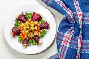 Salad with boiled beets, carrots, potatoes, pickles and fresh parsley. Top view (Flip 2019)