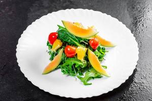 Salad with fresh avocado, cherry tomatoes, orange slices and arugula leaves (Flip 2019)