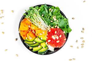 Salad with grapefruit, avocado, micro greenery and pine nuts on a white background. Top view (Flip 2020)
