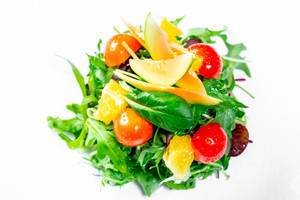 Salad with herbs, tomatoes, orange and avocado. Top view