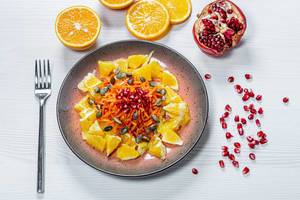 Salad with orange, carrot, pomegranate and pumpkin seeds. Top view. Healthy eating concept (Flip 2019)