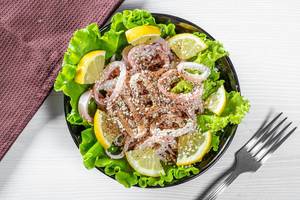 Salad with squid, lettuce, sesame and lemon