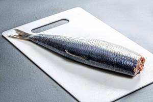 Salted herring on a white kitchen Board