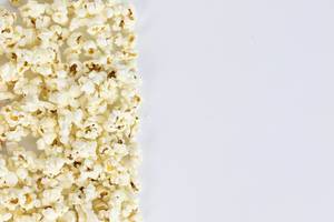 Salted popcorn grains on the white background