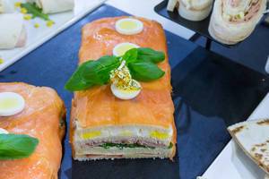 Sandwich mit Lachs, Ei und Blattgold in übergroßer Sushiform