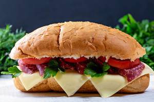 Sandwich with salami, tomatoes, cheese and herbs