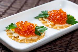 Sandwiches with salmon caviar and cheese on a white plate