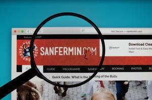 Sanfermin logo on a computer screen with a magnifying glass