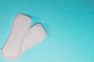 Sanitary napkins on bright background with copy space