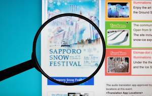 Sapporo Snow Festival text on a computer screen with a magnifying glass