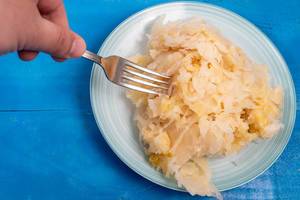 Sauerkraut on the plate and fork in the hand