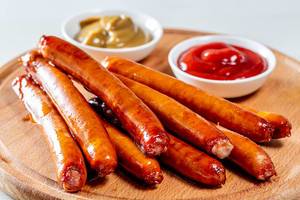 Sausages with two sauces on wooden kitchen Board