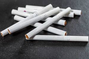 Scattered cigarettes on a black background, the concept of harm to health (Flip 2019)