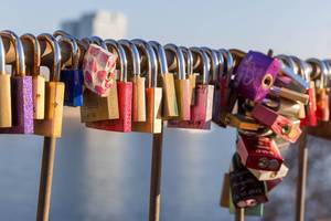 Schlösser hängen als Beweis der Liebe an einer Brücke in Köln