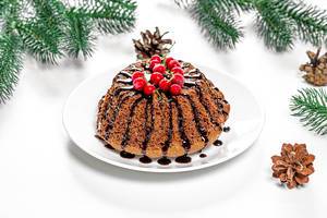 Schoko-Cupcake mit roten Johannisbeeren und Weihnachtshintergrund