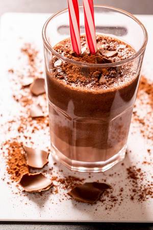 Schoko-Milchshake mit frischer Schokolade und Schokoladenpulver