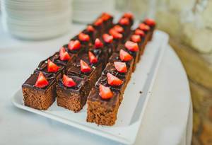 Schokoladenkuchen in kleine Stücke geschnitten, mit Erdbeeren verziert