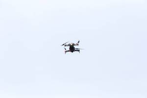 Schwarze Drohne mit vier Propellern fliegt am Himmel