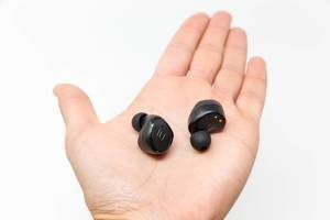 Schwarze kabellose und bluetoothfähige Kopfhörer S8 Plus von Antimi auf einer Hand vor weißem Hintergrund