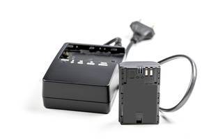 Schwarze Kamera Batterie mit schwarzer Ladestation auf weißem Hintergrund