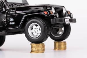 Schwarzes Jeep-Spielzeugauto mit den Rädern auf zwei Stapeln 20-Cent-Münzen
